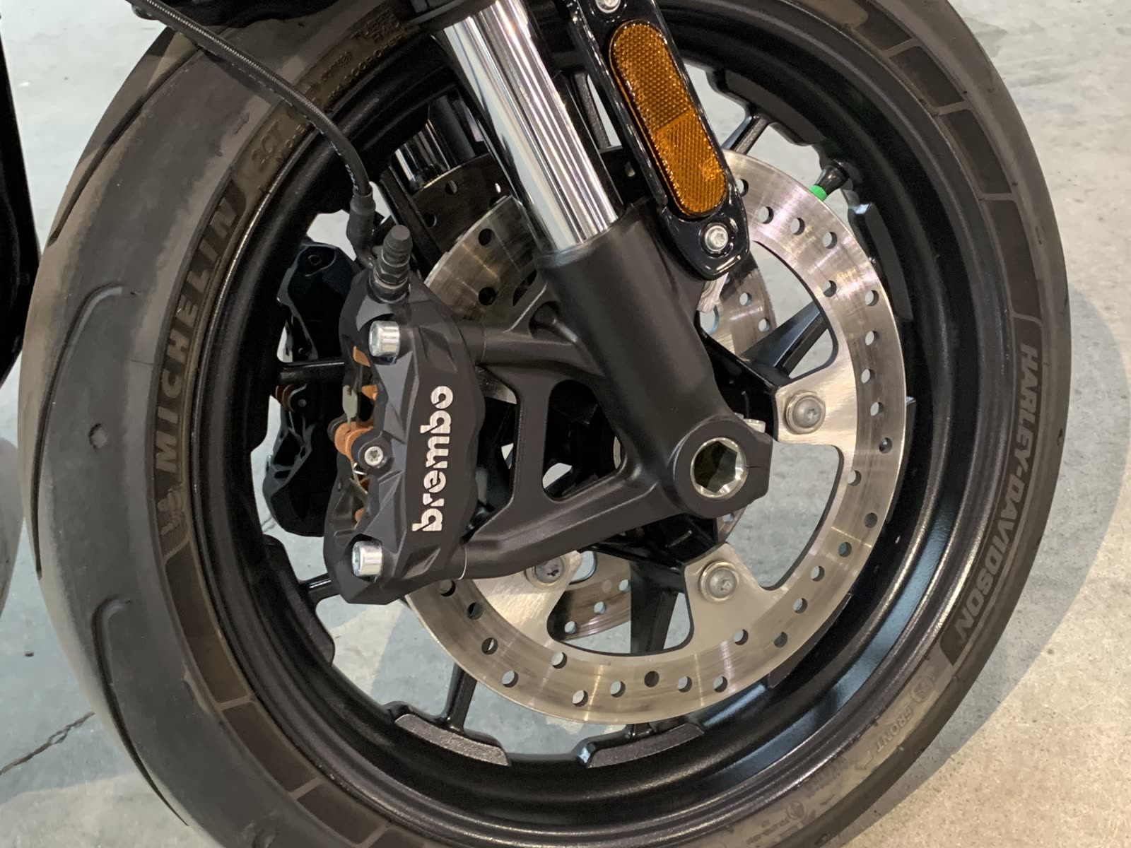 A close-up of a motorcycle wheel with a Brembo brake caliper and Michelin tire
