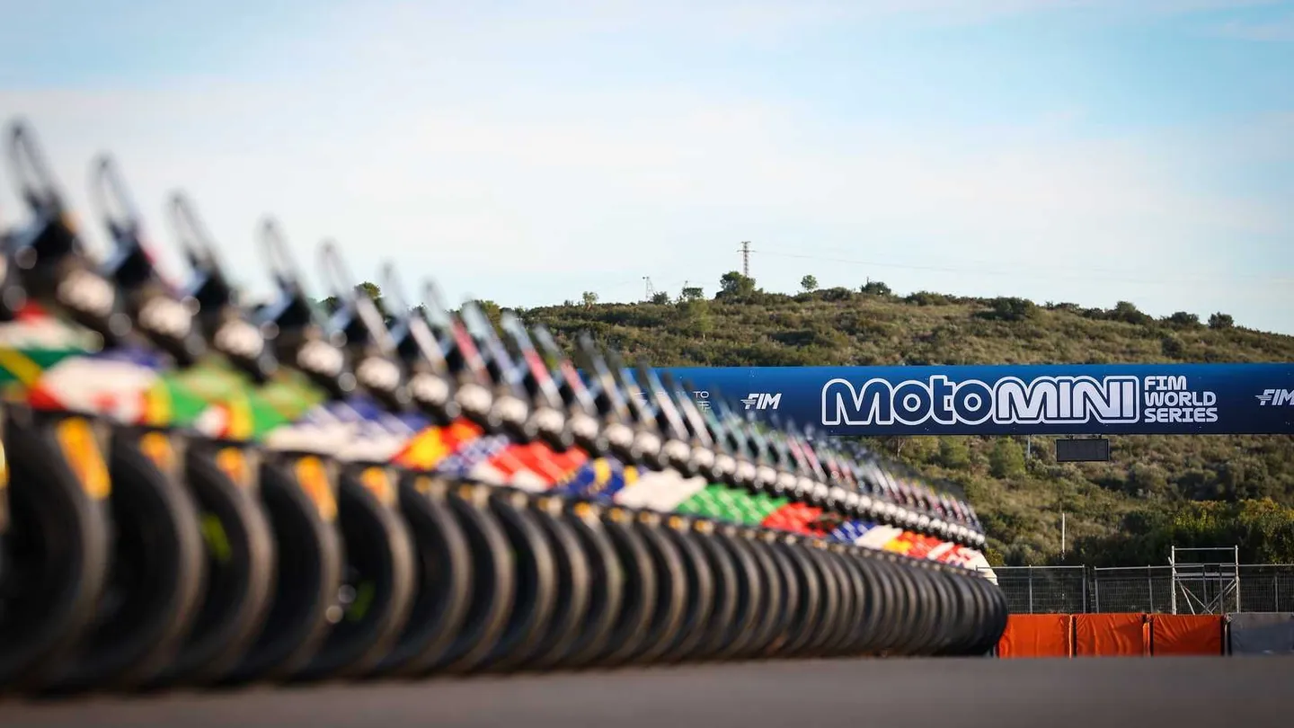 A row of race bikes on the grid beneath the MotoMini FIM World Series banner