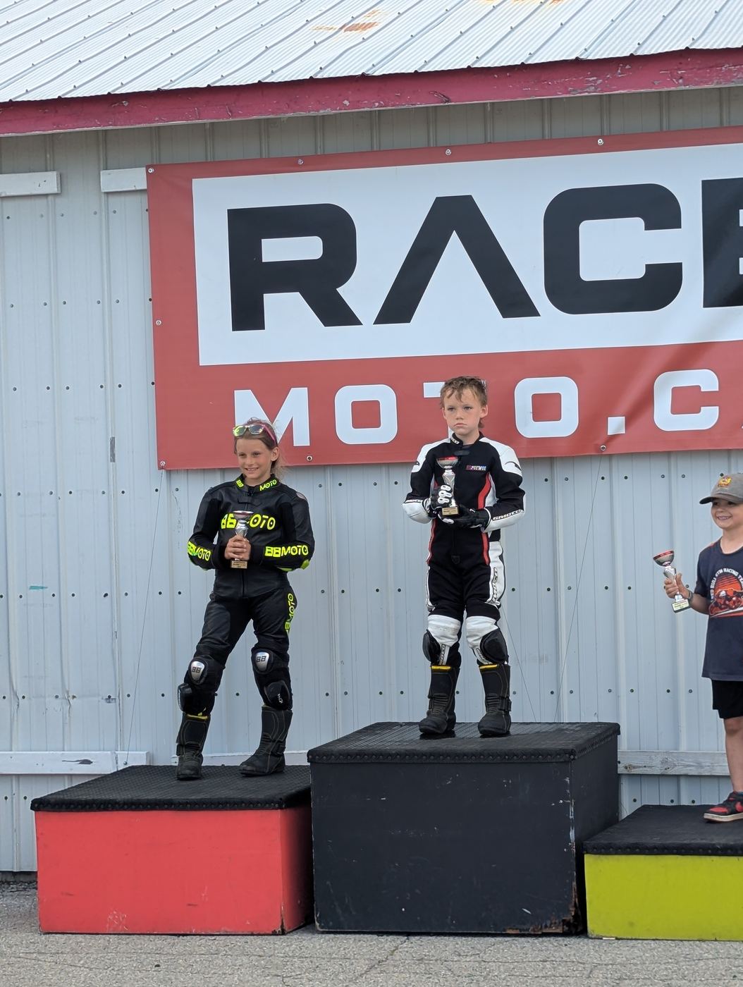 Young riders holding their trophies on the podium boxes after a club round